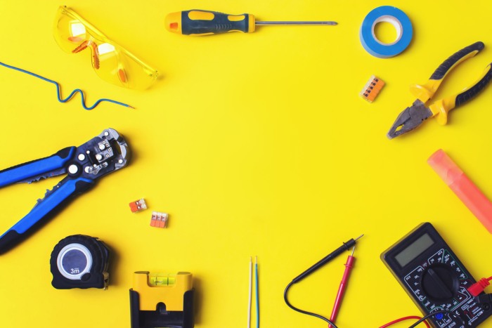 Set of electrician's tools on yellow background