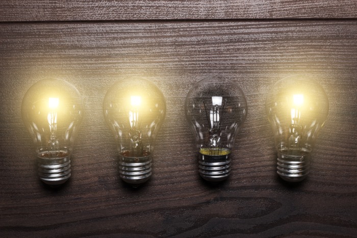 glowing bulbs weak link concept on the wooden background